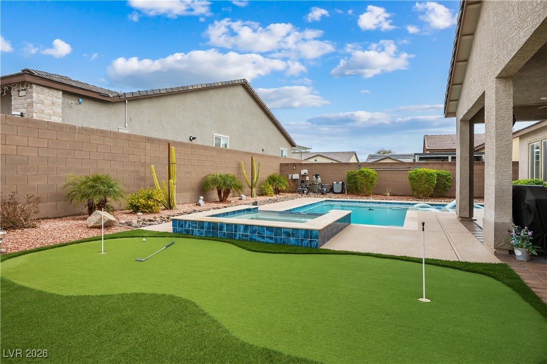 3018 Bounding Home Road North Las Vegas, NV 89086 - Photo 35 of 43 View of pool with a putting green, a patio area, a fenced backyard, and a pool with connected hot tub