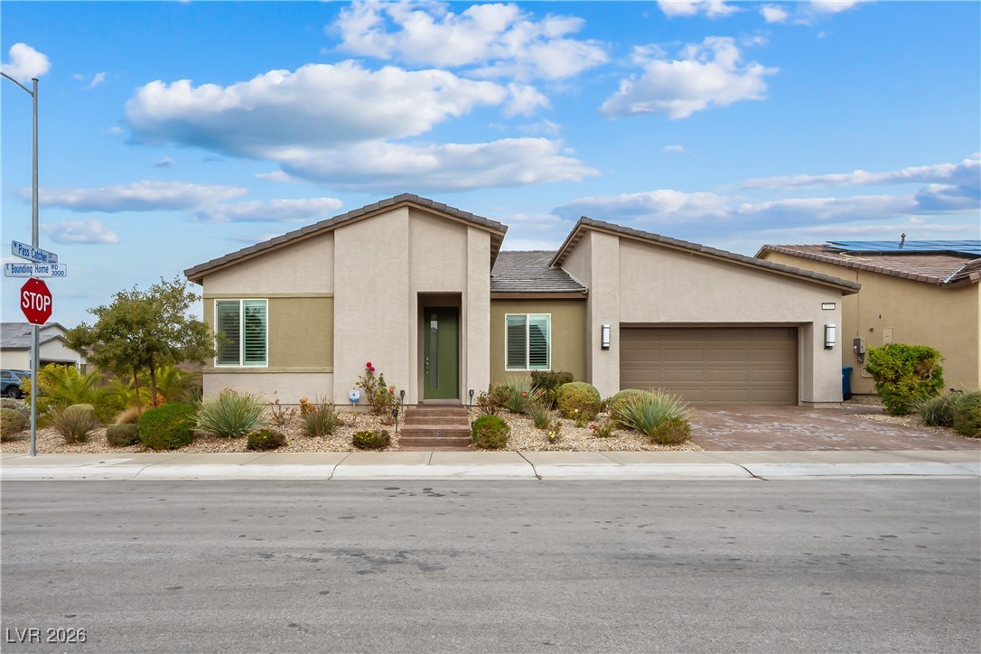 3018 Bounding Home Road North Las Vegas, NV 89086 - Photo 38 of 43 View of front of property featuring stucco siding, an attached garage, and driveway
