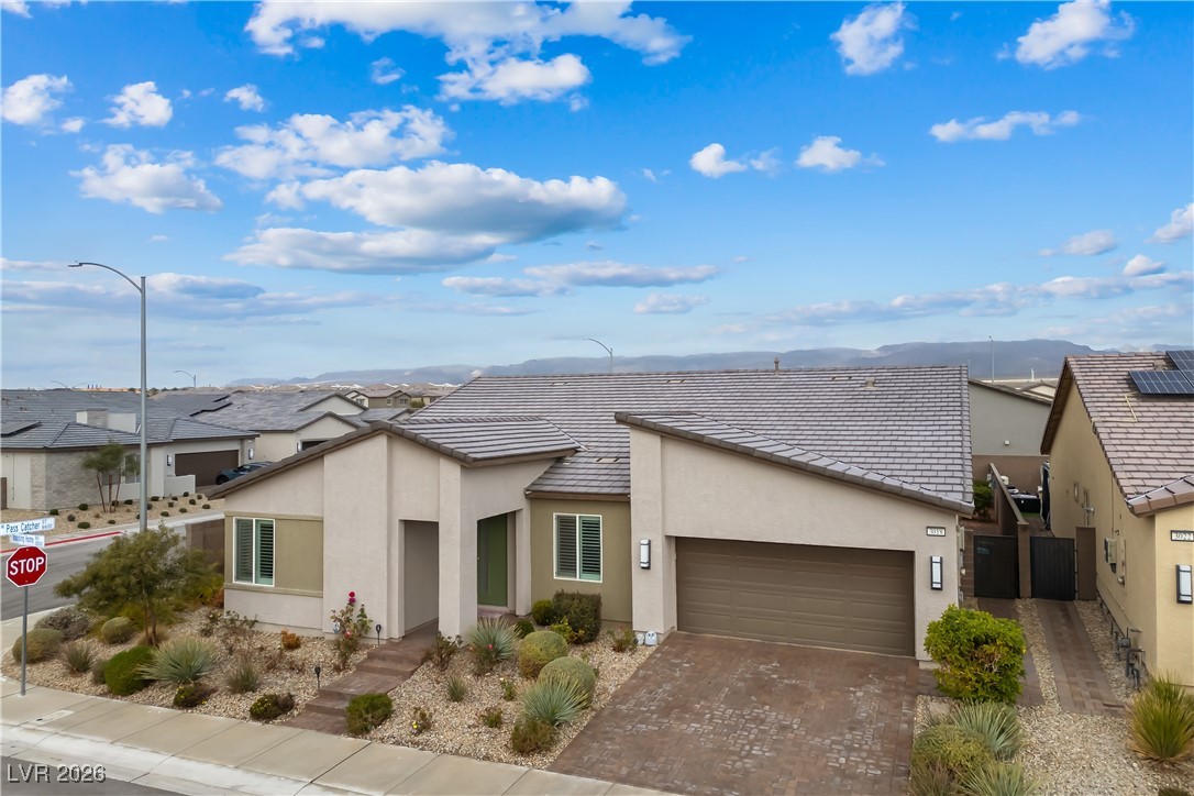 3018 Bounding Home Road North Las Vegas, NV 89086 - Photo 5 of 43 View of front of house featuring stucco siding, driveway, a garage, and a mountain view