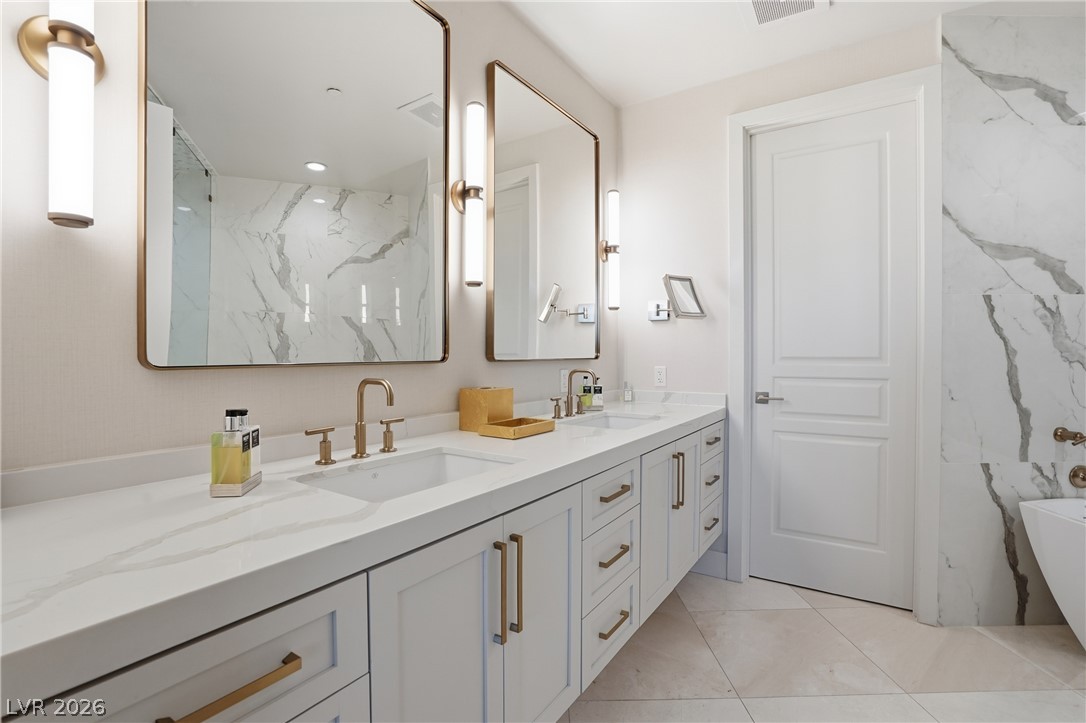 360 East Desert Inn Road, Unit 1701 Las Vegas, NV 89109 - Photo 19 of 33 Double vanities and elegant marble accents define this generously appointed primary bathroom.