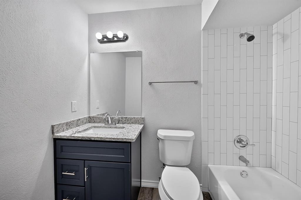 1801 East Grauwyler Road, Unit 101 Irving, TX 75061 - Photo 14 of 39 a bathroom with a sink a toilet and shower