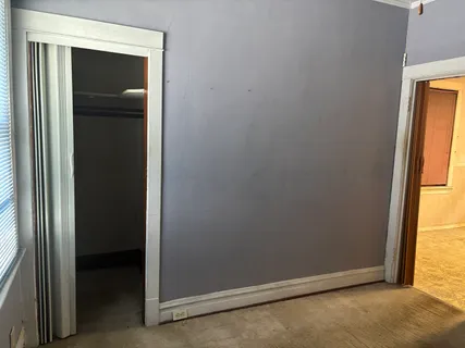 an empty room with windows and closet