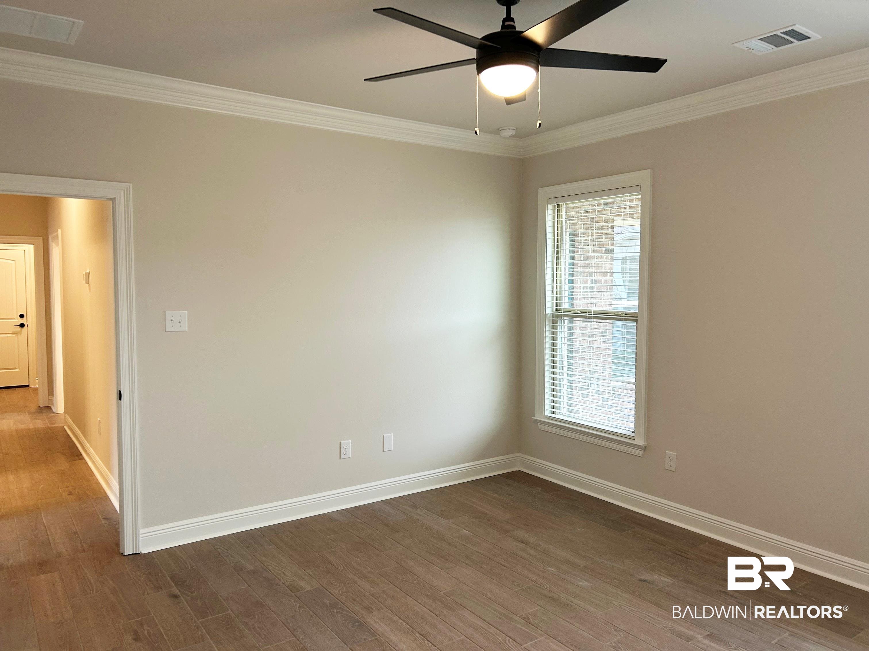 873 Sumter Loop Foley, AL 36535 - Photo 22 of 26 Empty room with crown molding, wood finished floors, and ceiling fan
