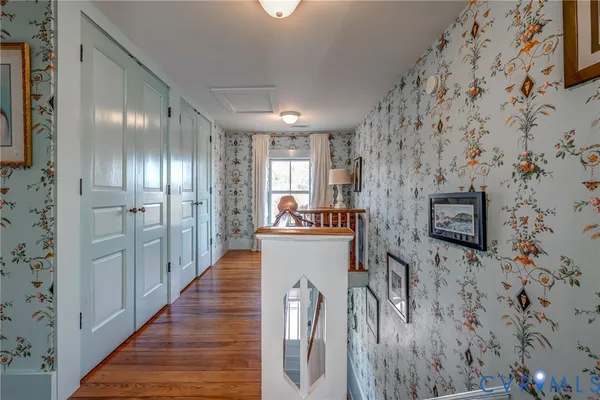 a view of a hallway with wooden floor and staircase