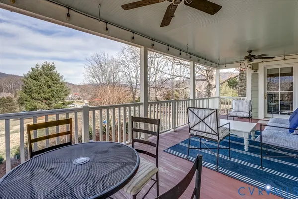 a view of a patio with table and chairs with wooden floor and fence