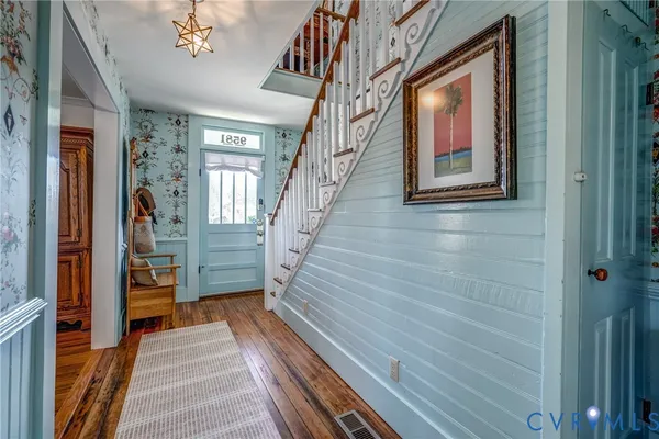 a view of a hallway with wooden floor and staircase