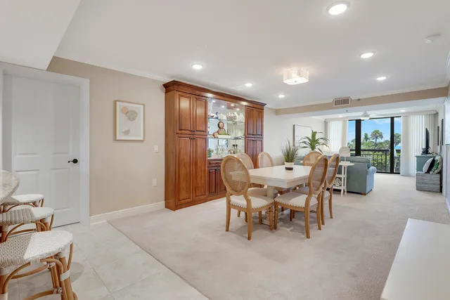a dining room with furniture and a floor to ceiling window