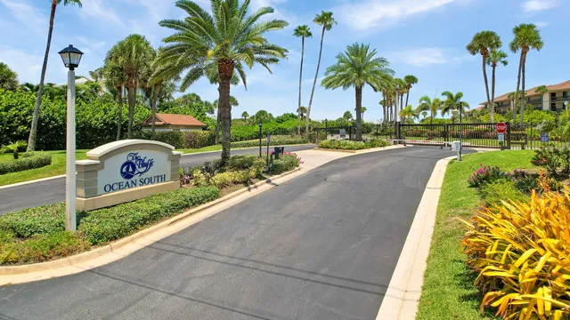 a front view of multi story residential apartment building with a yard and potted plants