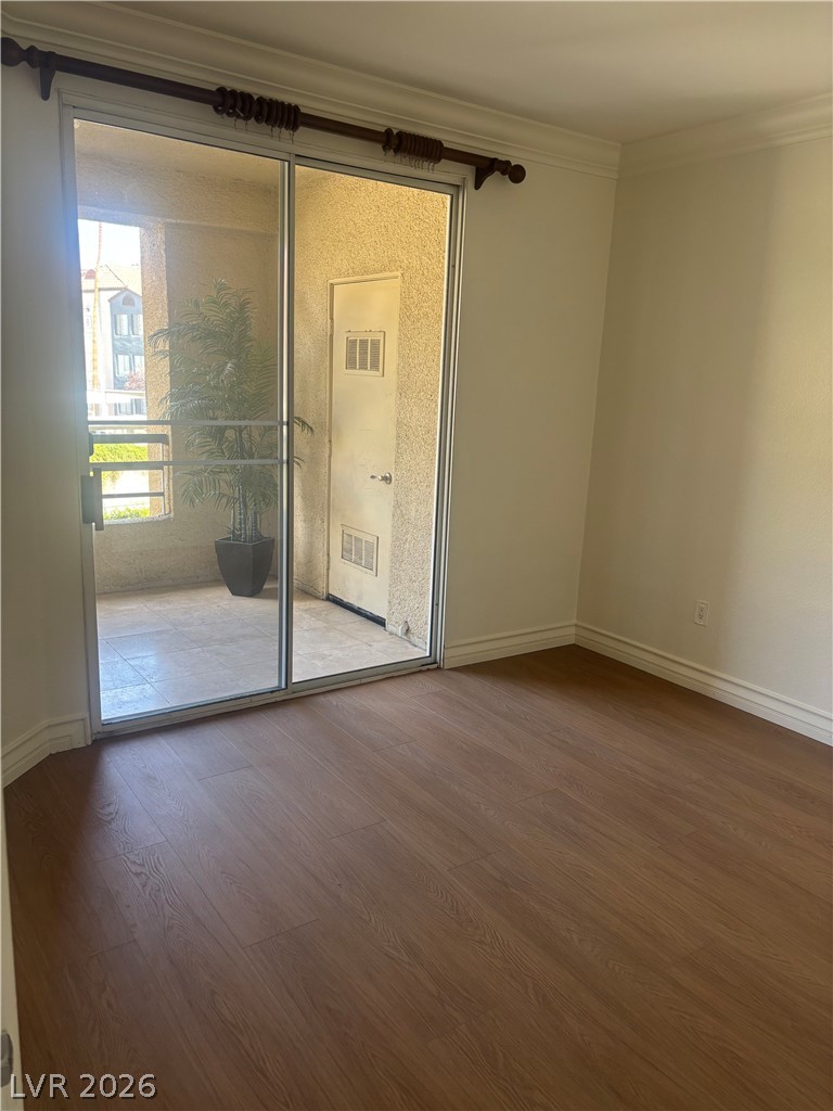 210 East Flamingo Road, Unit 123 Las Vegas, NV 89169 - Photo 8 of 17 Sliding glass doors connect the wood-floored interior directly to a private covered patio.