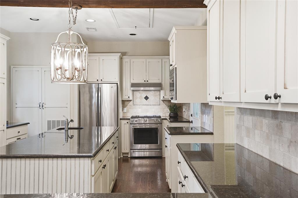 9121 6th Street Frisco, TX 75033 - Photo 7 of 27 a kitchen with stainless steel appliances a stove a refrigerator and white cabinets