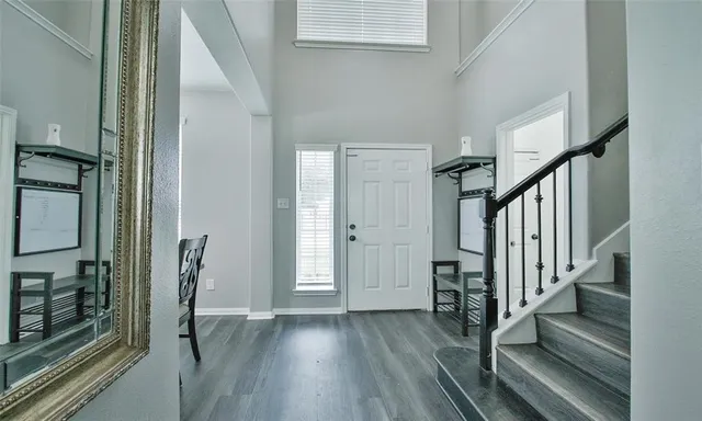 a view of a hallway with wooden floor and staircase