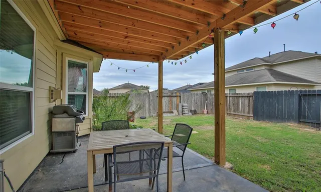 a view of a porch with furniture and a yard