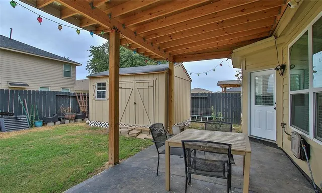 a backyard of a house with table and chairs