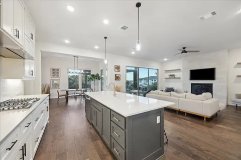 a large white kitchen with a large island in the center and white cabinets