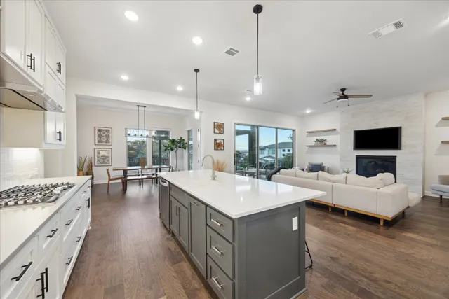 a large white kitchen with a large island in the center and white cabinets