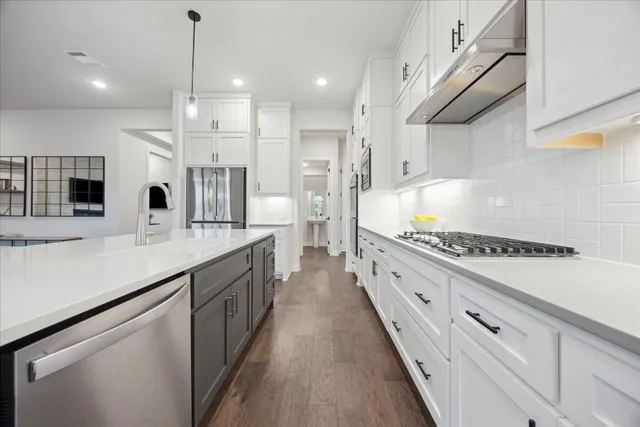 a large kitchen with stainless steel appliances lots of counter space and wooden floor