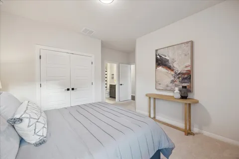 a bedroom with a bed and a painting on the wall