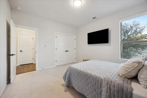 a bedroom with a bed and a flat screen tv