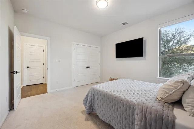 a bedroom with a bed and a flat screen tv