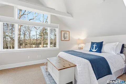 a bed sitting in a bedroom next to a window