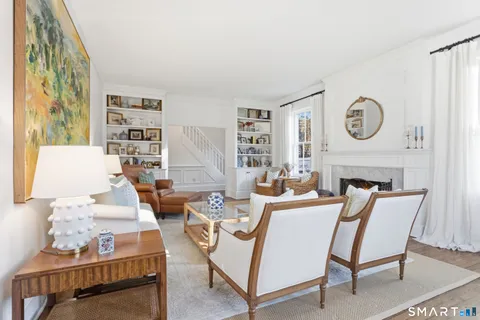 a living room with furniture a rug and a clock