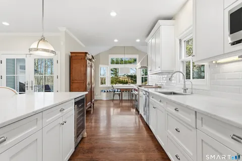 a large kitchen with kitchen island granite countertop lots of counter space and windows