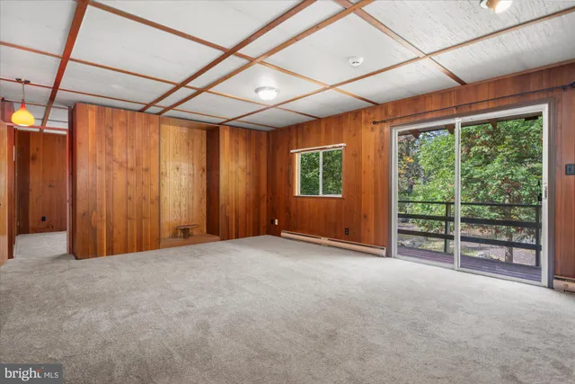 an empty room with large windows and wooden walls