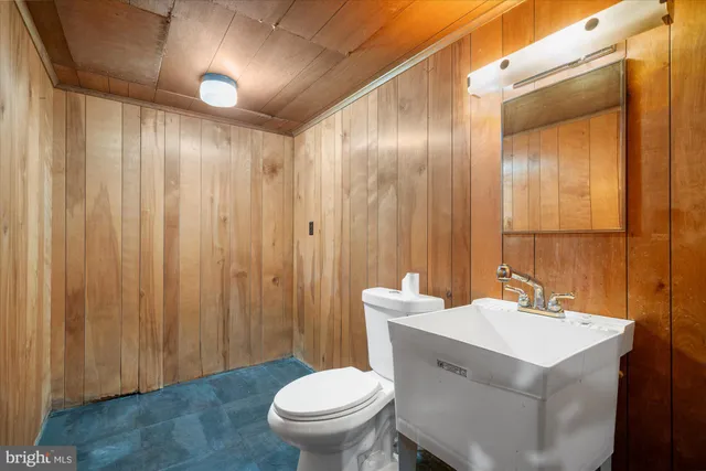 a bathroom with a sink a toilet a mirror and shower curtain