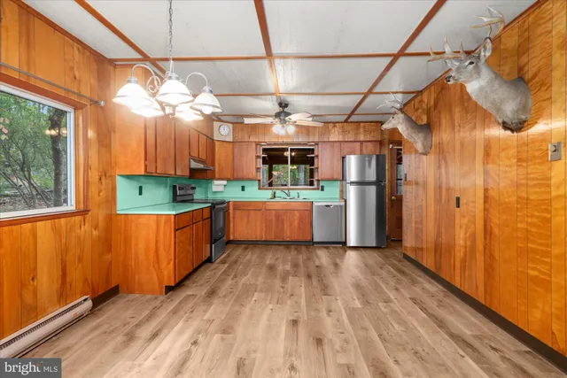 a kitchen with stainless steel appliances granite countertop a refrigerator and a wooden floors
