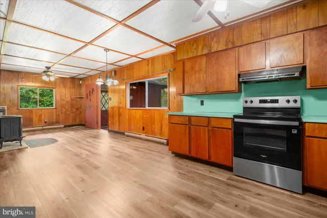 a kitchen with stainless steel appliances wooden cabinets and a stove top oven