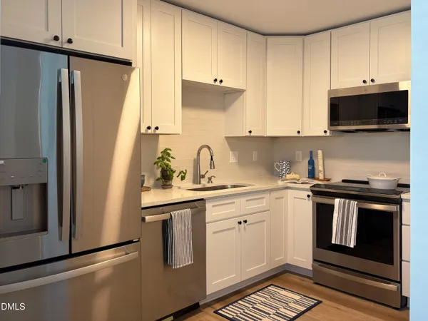 a kitchen with stainless steel appliances a stove a sink and a refrigerator