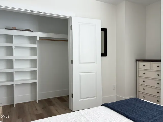 a view of a bedroom with closet and wooden floor