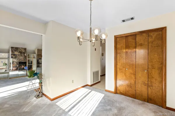 a view of a livingroom with a chandelier & a window