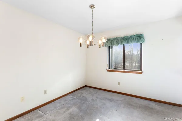 a view of a room with window and chandelier fan