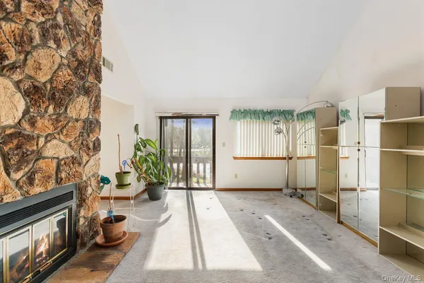a living room with furniture a large window and stainless steel appliances