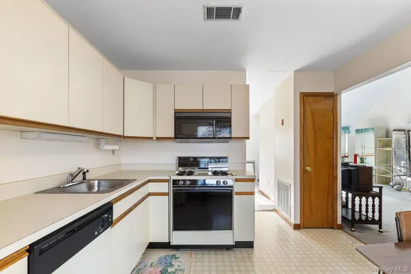 a kitchen with stainless steel appliances a stove sink and cabinets