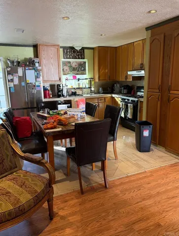 a work place with stainless steel appliances kitchen island granite countertop a refrigerator and a stove top oven