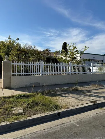 a view of a garden with wooden fence