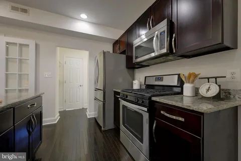a kitchen with stainless steel appliances granite countertop a stove a microwave and cabinets