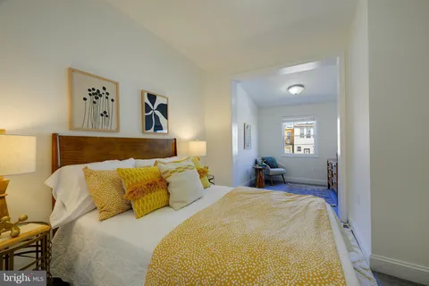 a bed sitting in a bedroom and painting on the wall