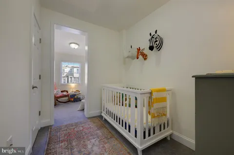 a view of a bedroom with furniture and baby crib