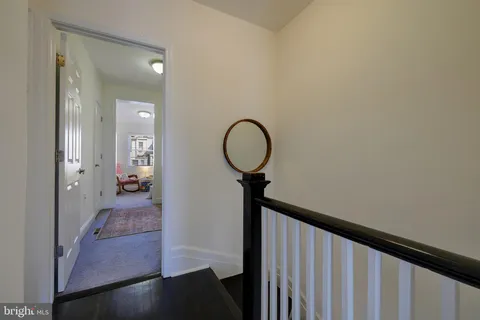 a view of a hallway with a livingroom and a mirror