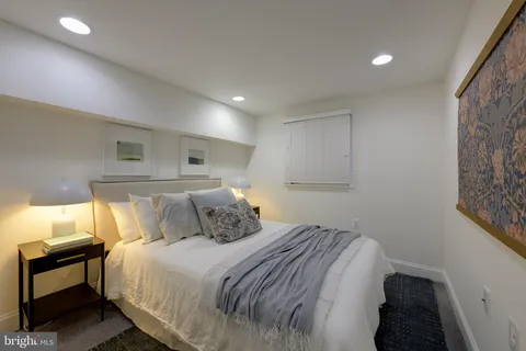 a bedroom with a bed and a lamp with the wooden floor