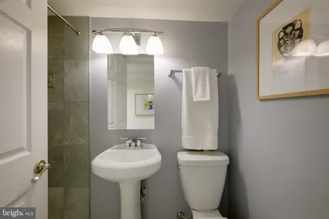 a bathroom with a sink mirror and toilet