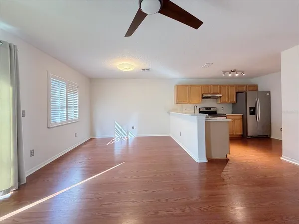 a view of a kitchen with a sink stove cabinets and empty room