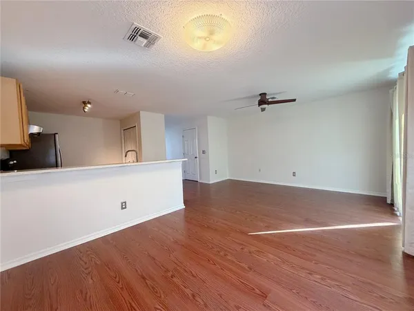 an empty room with a wooden floor and windows