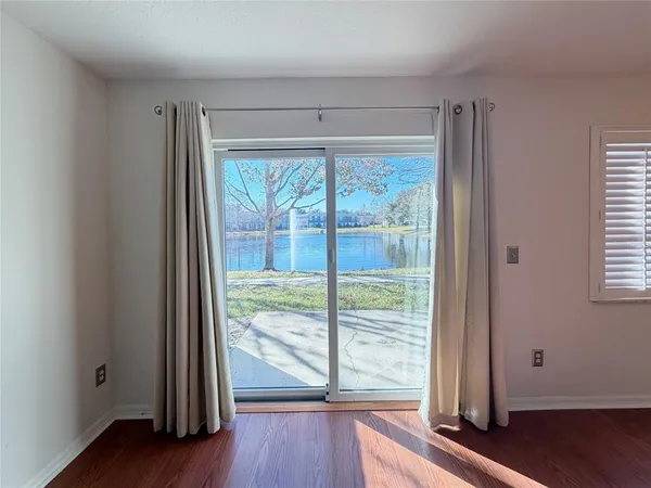 a view of a room with wooden floor and a window