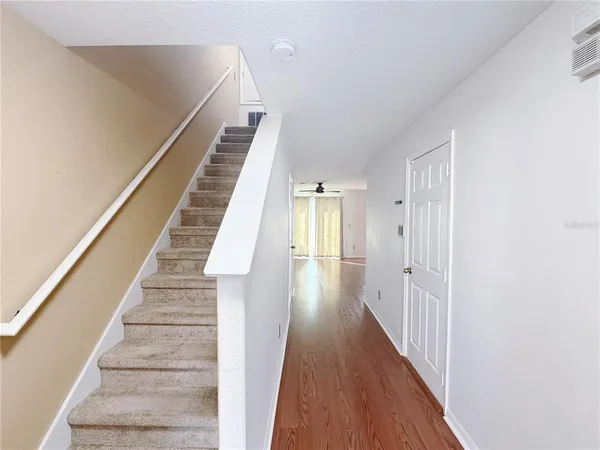 a view of a hallway with wooden floor and entryway
