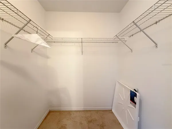 a view of walk in closet with empty racks