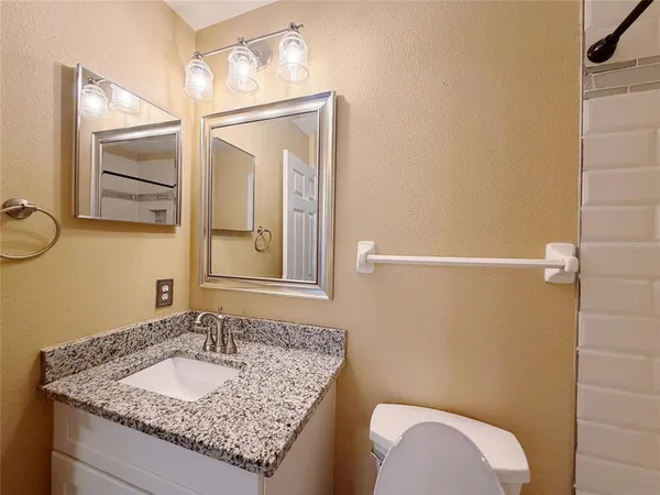 a bathroom with a granite countertop sink and a mirror
